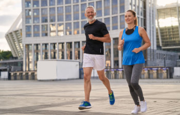 mature man and woman exercising and jogging together in the city on a warm summer